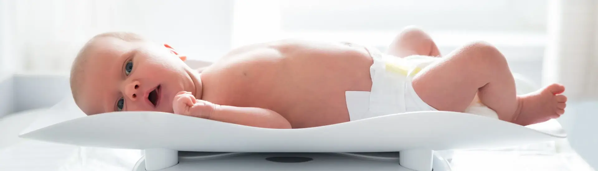 Baby op weegschaal nieuwe groeicurven