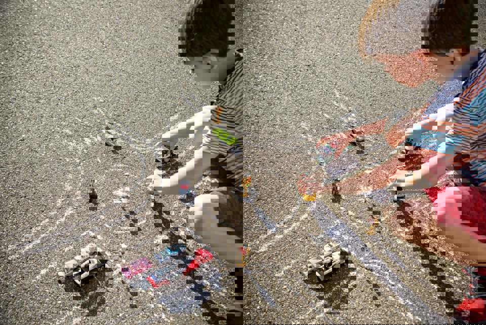 Jongen speelt op straat met auto's: Verkeer op kindermaat