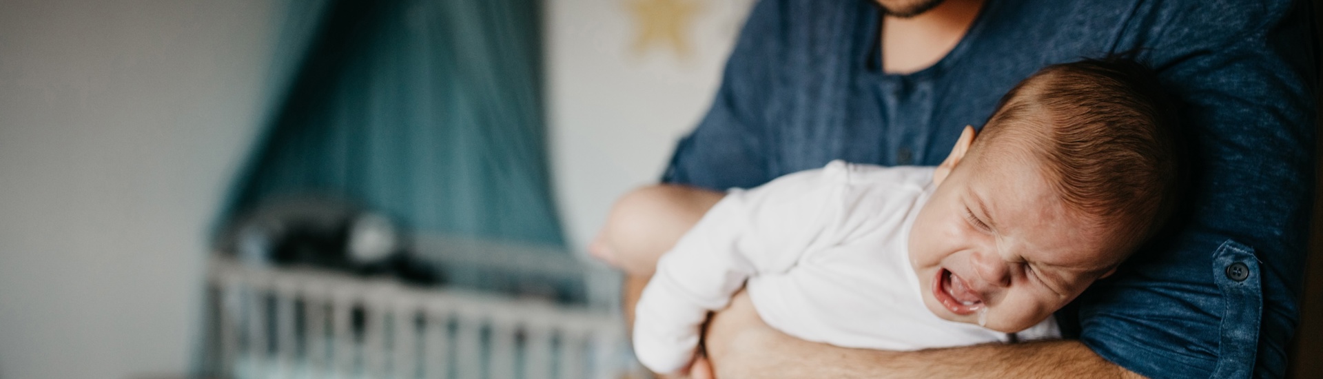 Vader met huilbaby in armen