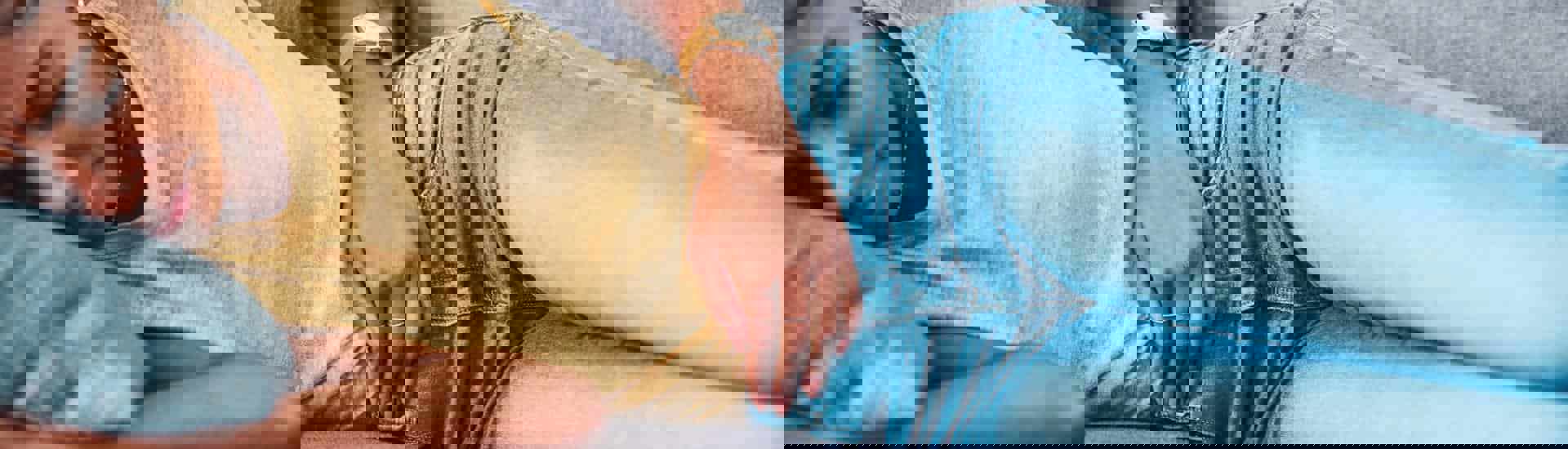 Vrouw met menstruatiepijn ligt in zetel