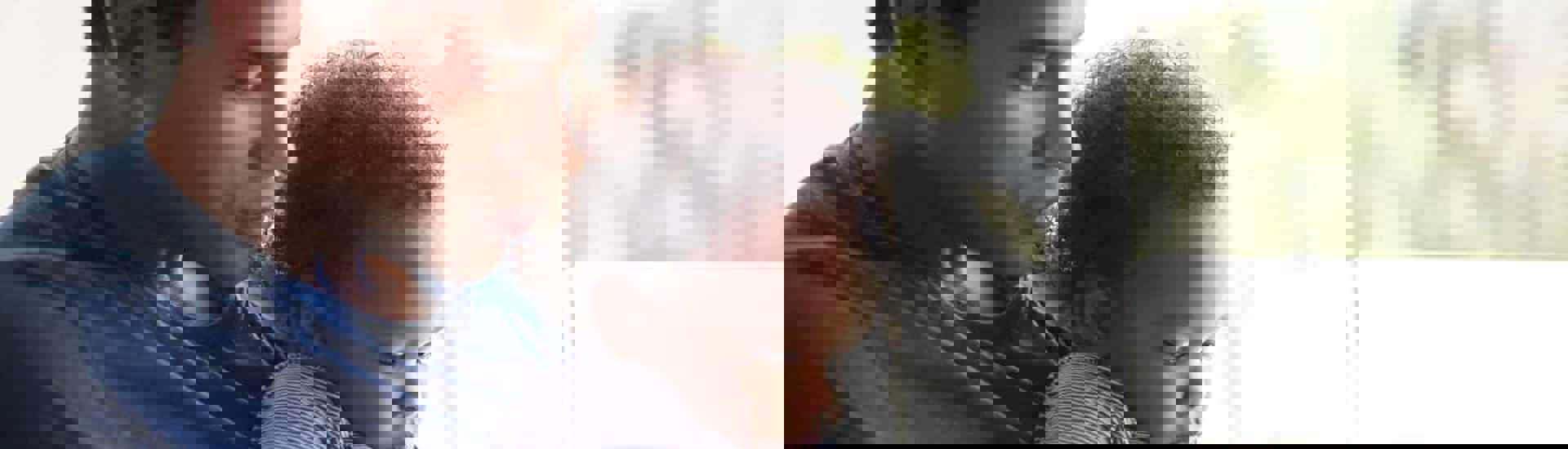 Papa en kind lezen boekje om overlijden van broer of zus te verwerken