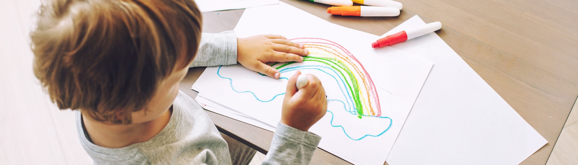 Regenboogbaby: jong kind tekent een regenboog