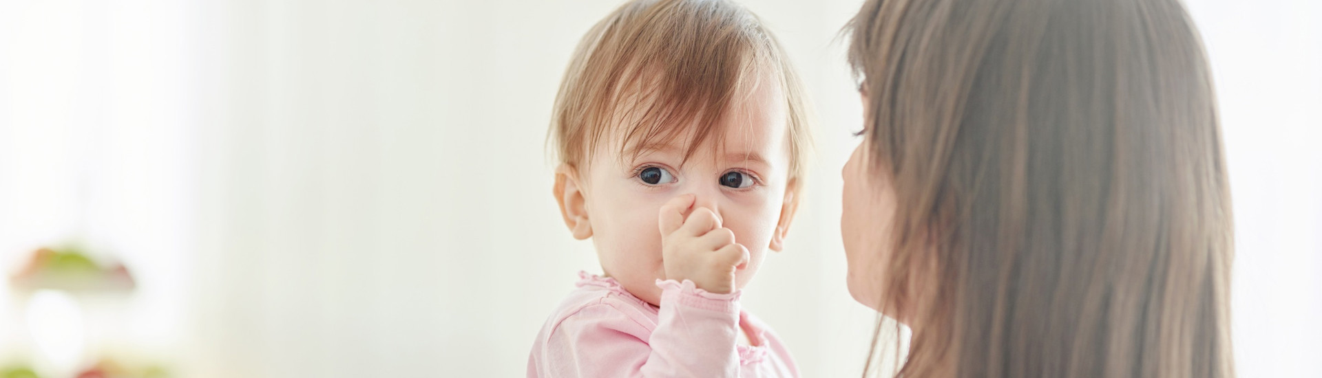 duimzuigend kind op schouder mama
