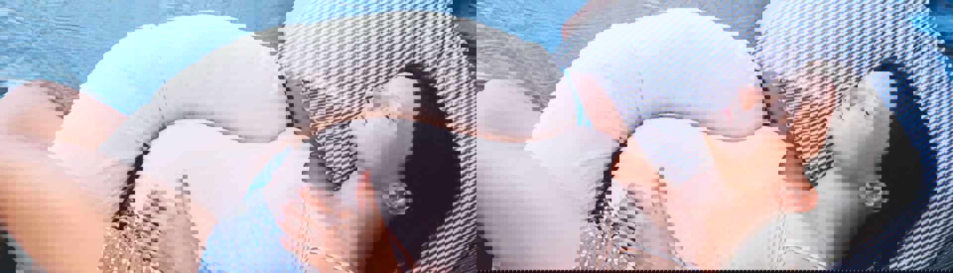 zwangere vrouw met zwangerschapskussen: slapen met bekkenpijn