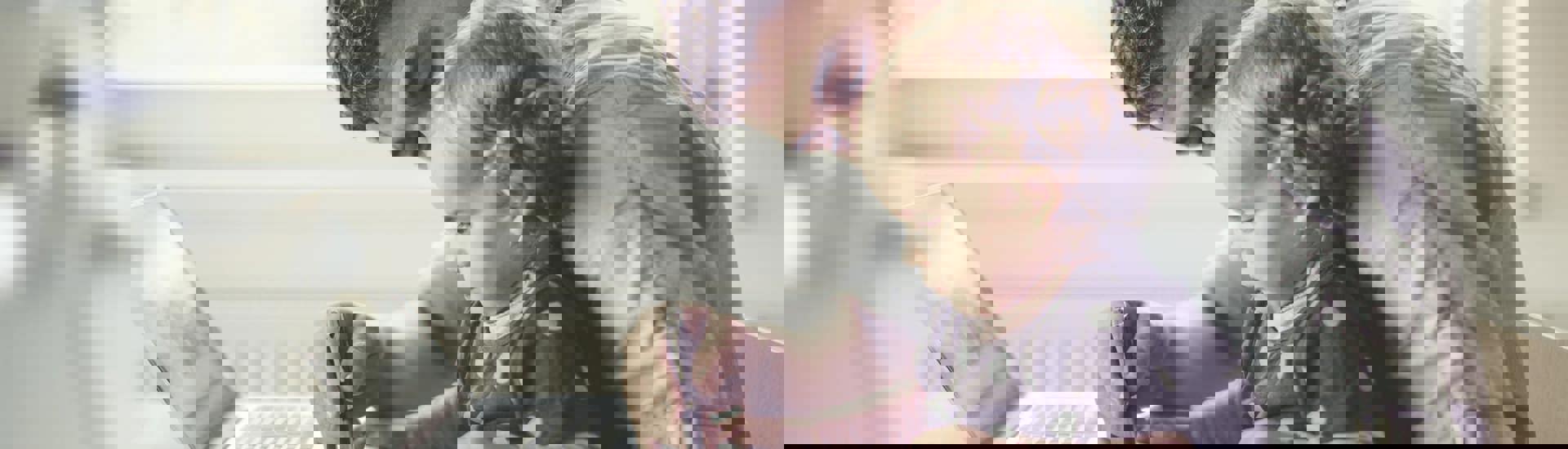 Papa en kind aan computer: budget eerlijk verdelen als samengesteld gezin