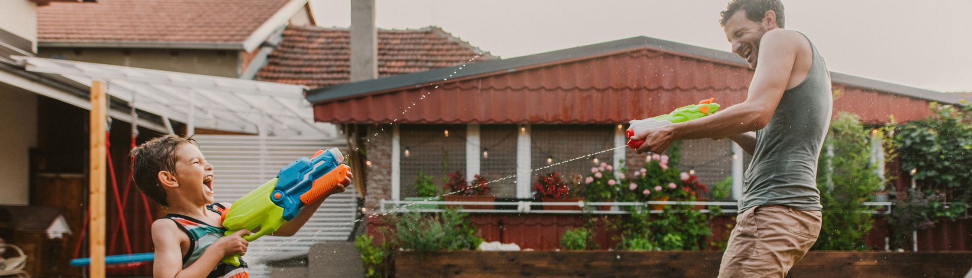 Kind en vader spelen met waterpistool speelgoedgeweer