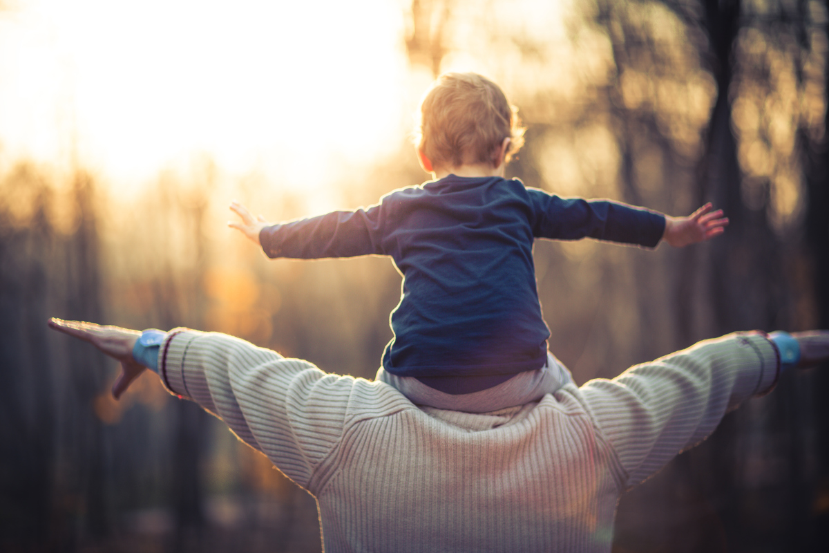 kind op schouders papa