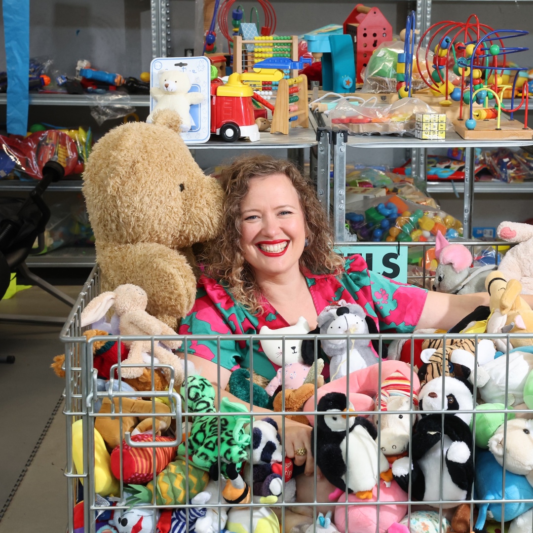 Katrijn Van Bouwel in mand vol speelgoed in tweedehandswinkel