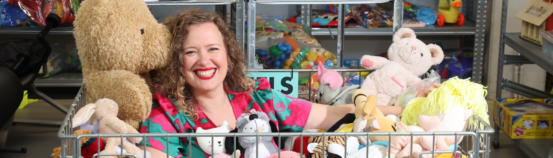 Katrijn Van Bouwel in mand vol speelgoed in tweedehandswinkel
