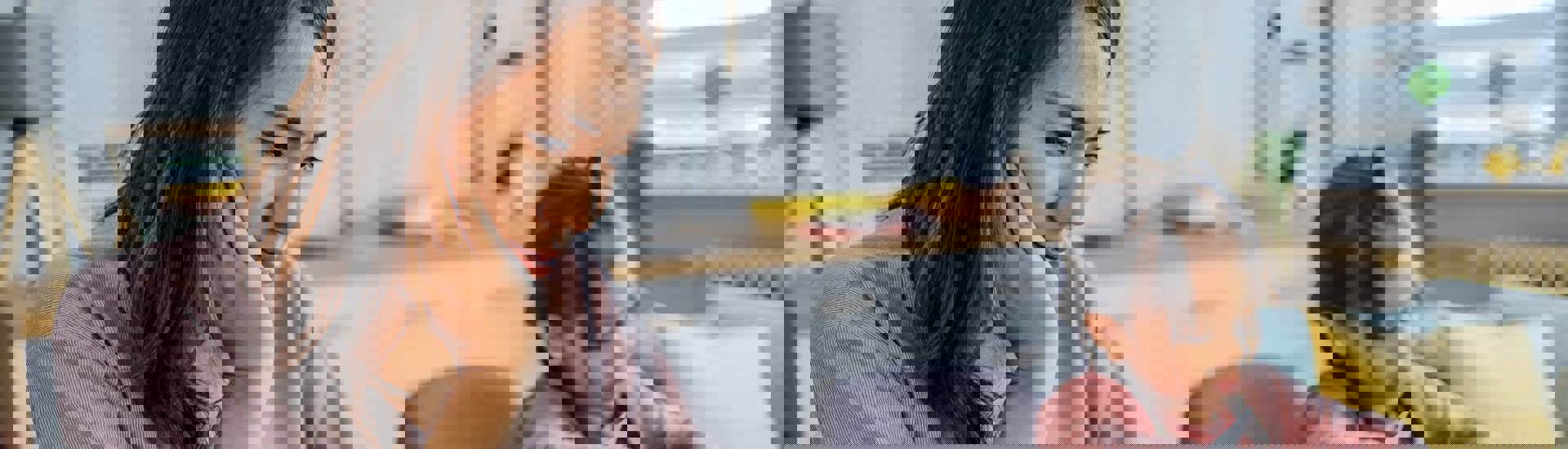 Mama bekijkt het gezinsbudget met dochter op de achtergrond: tips van  Djennah Van Nieuwenhove