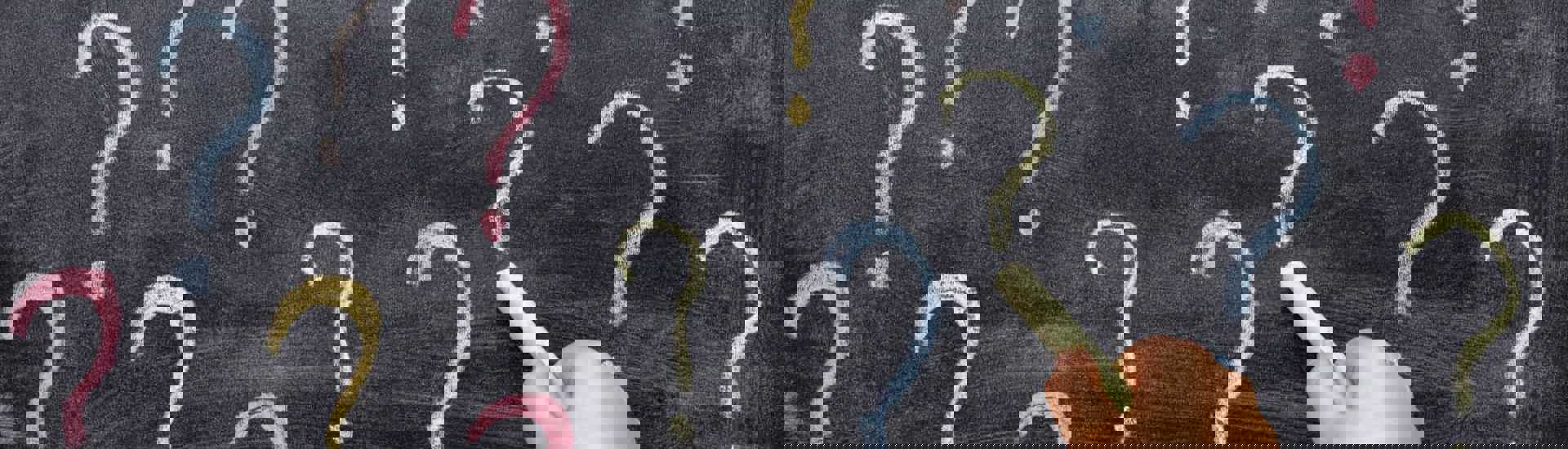 Kinderhand tekent vraagteken op bord: waarom vragen kleuter