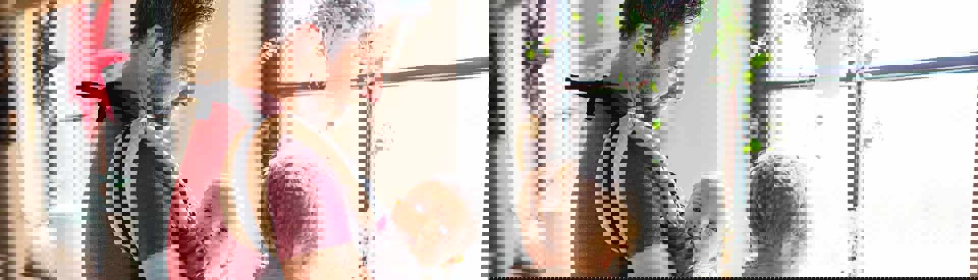 Papa draagt baby in een draagzak