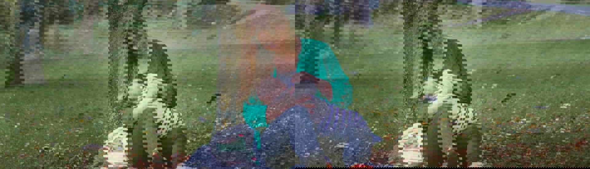 Mama geeft borstvoeding in park: recht op borstvoedingsverlof