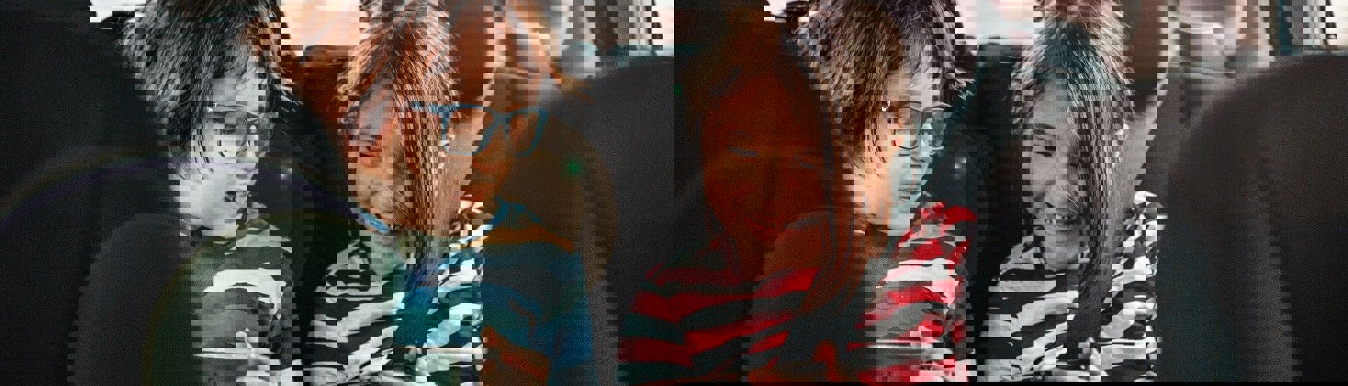 Kinderen zitten met smartphones in de auto