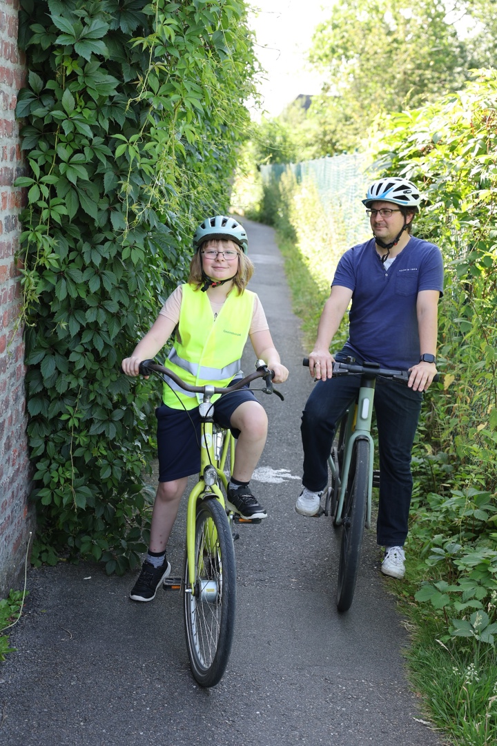 Kind en vader op de fiets: veilig naar school met kindlint