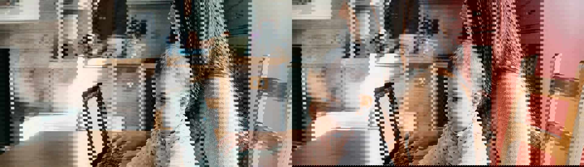 Mama met laptop en baby op schoot Thuiswerken met baby, peuter of kleuter