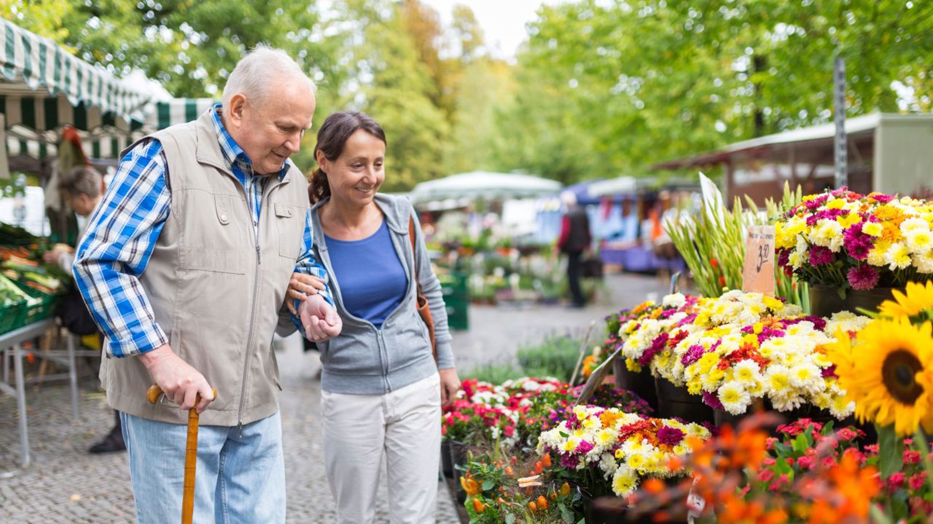 Vrouw helpt oudere man met boodschappen